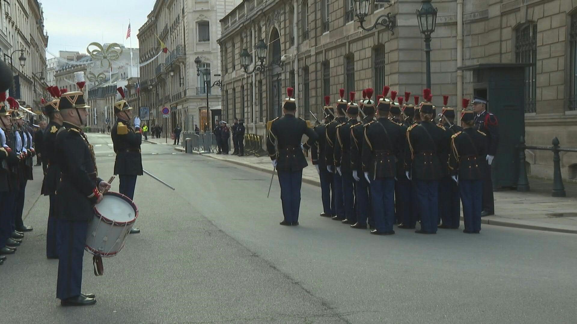 Emmanuel Macron presides over the changing of the guard ceremony