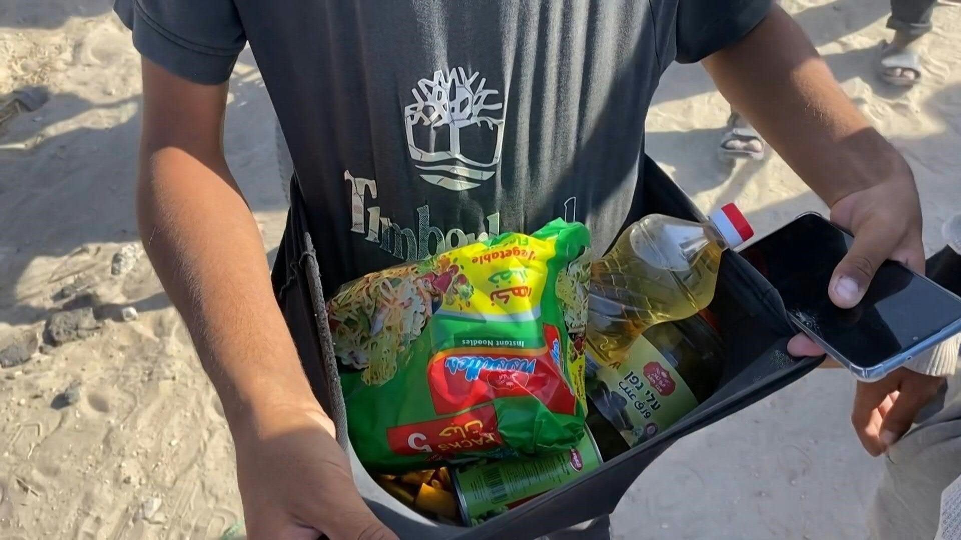 Gazans carry food aid from new distribution centre in Rafah