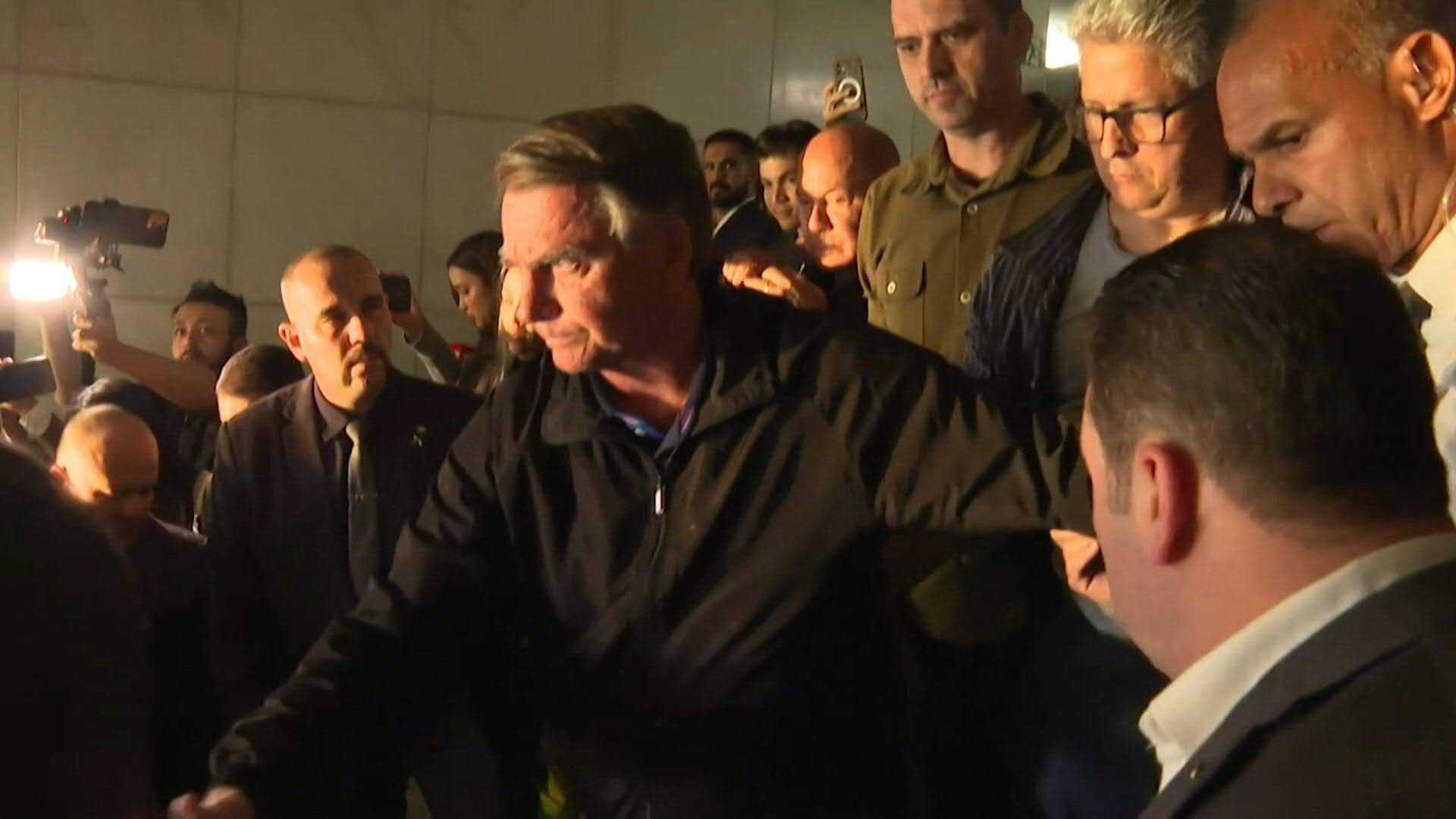 Brazil's ex-president Jair Bolsonaro flashes electronic ankle monitor to press