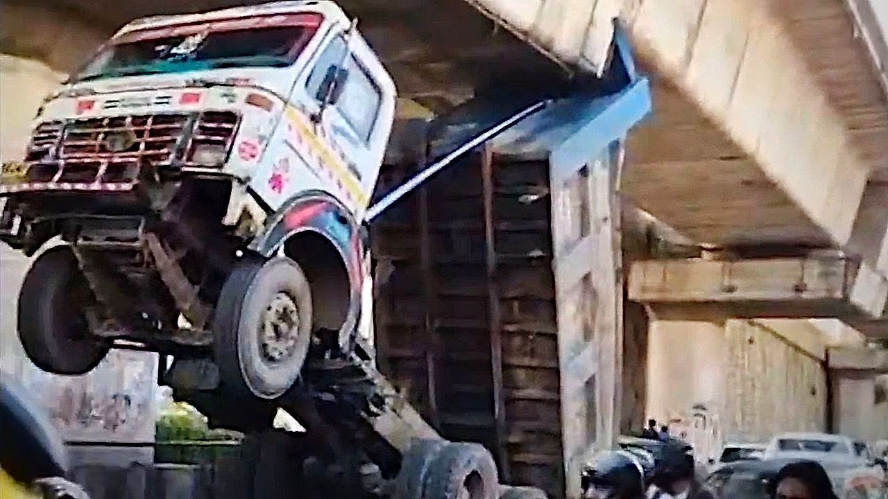 Video: An overloaded garbage truck overturned and was left hanging from an overpass in India