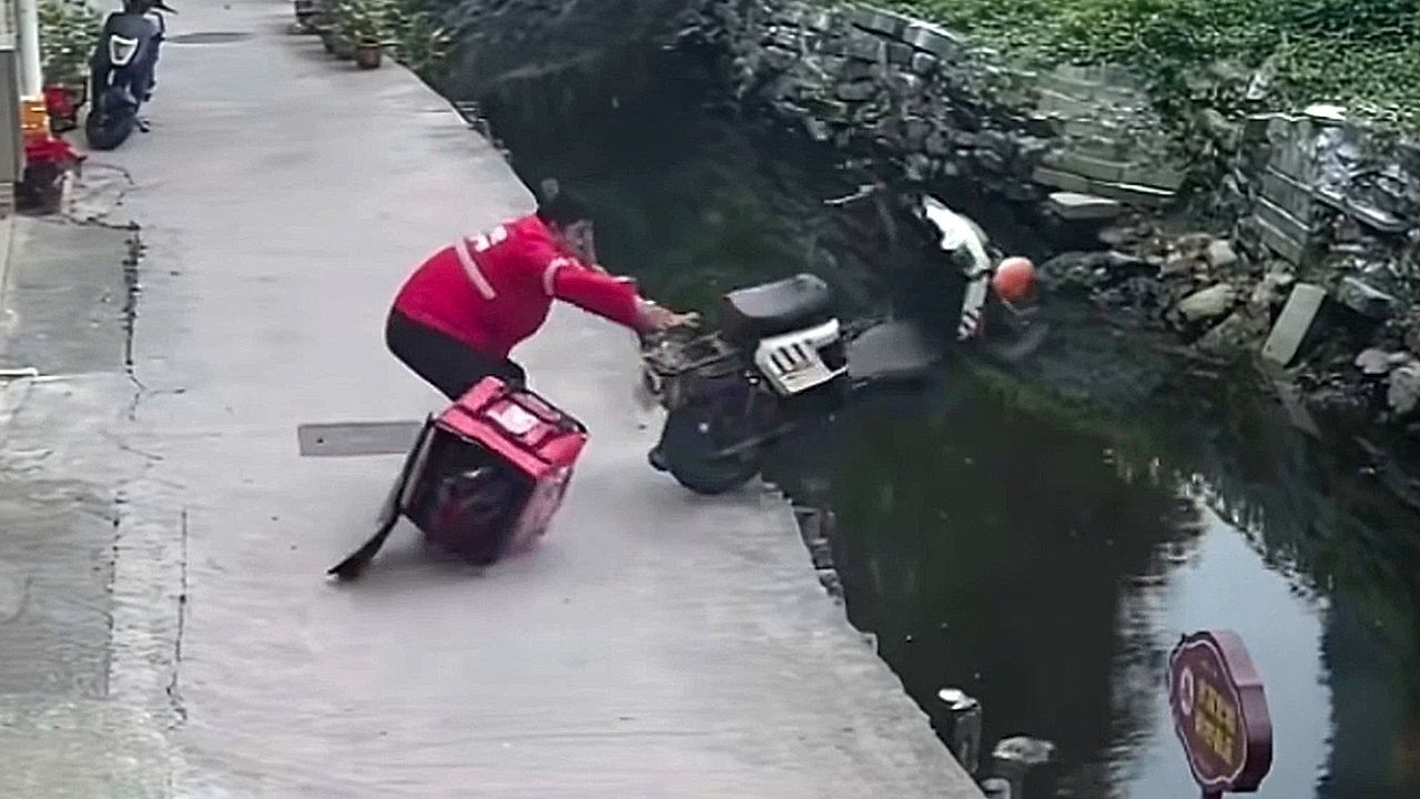 Video: Daneben gegriffen: Lieferfahrer katapultiert Roller versehentlich in Bach