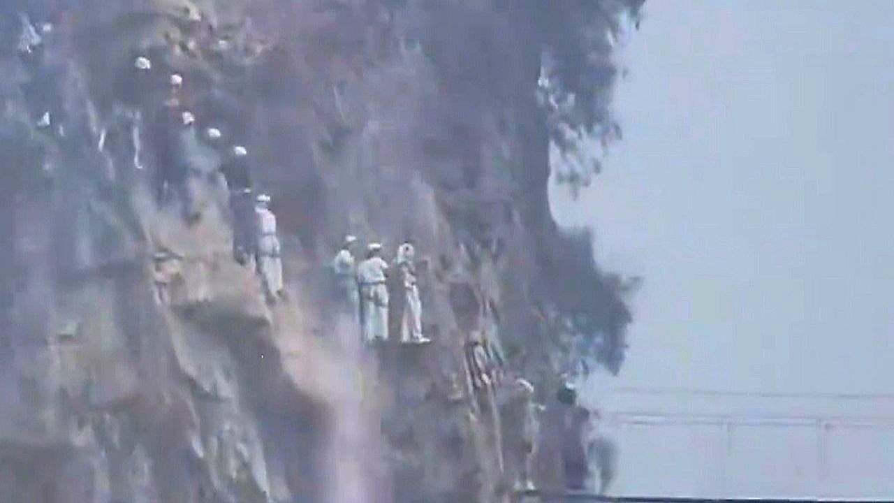 Video: Dozens of climbers cling to cliff face as torrential rain turns mountain route slippery