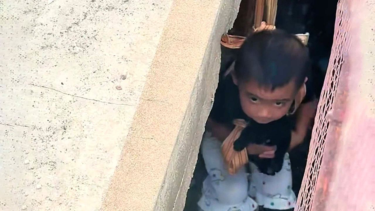 Video: Father lowers young daughter into gap between buildings to rescue trapped puppy